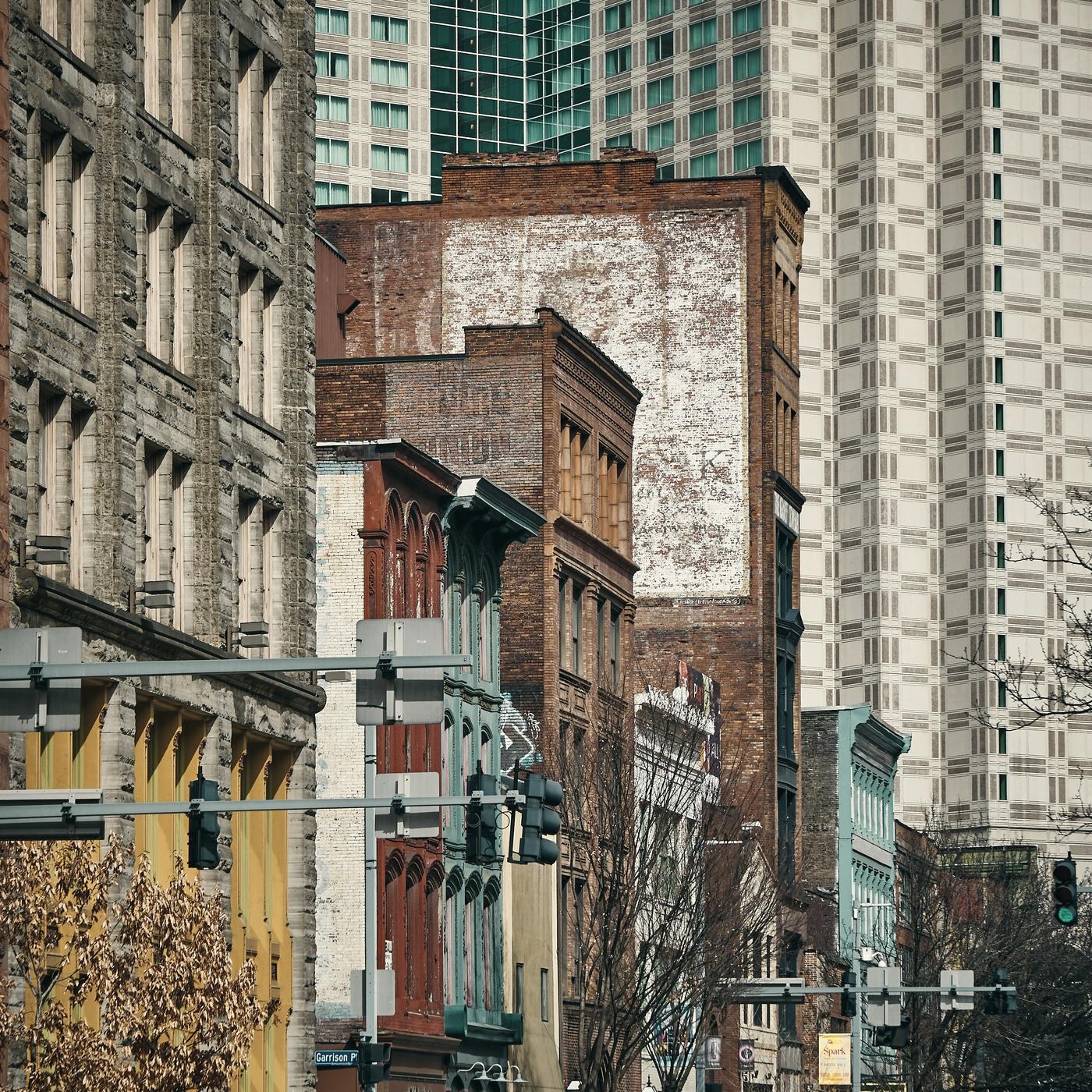 Nineteenth-century brick buildings against downtown Pittsburgh towers