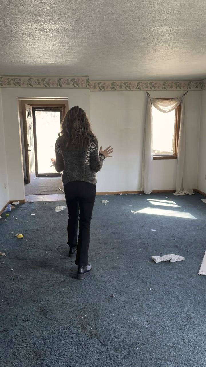 Walking through a vacant house with debris on the carpet