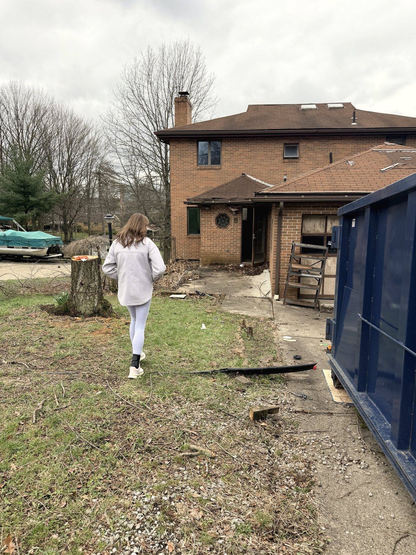 A brick house with a dumpster in the driveway